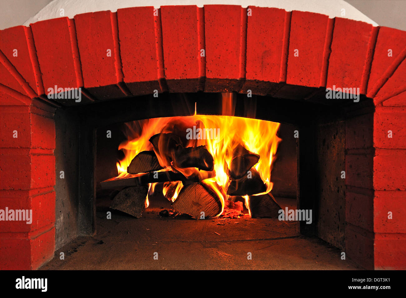 Burning logs in a tarte oven, red brick frame, Hotel Heckenrose, Ringsheim, Baden-Wuerttemberg Stock Photo