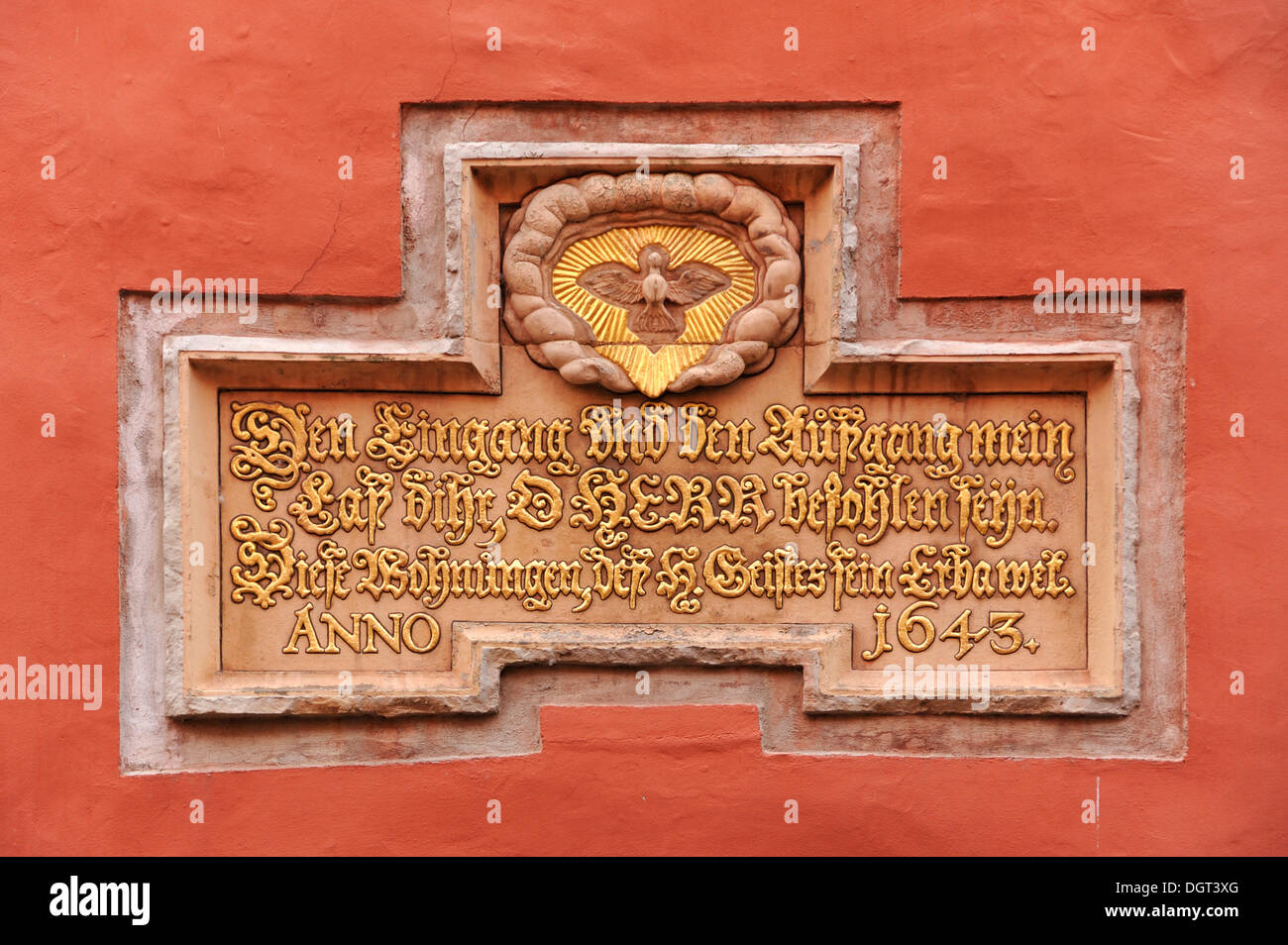 Gold-plated Christian quote and a dove as a symbol of the Holy Spirit above the doorway to the Heilgeist-Wohnungen apartments Stock Photo