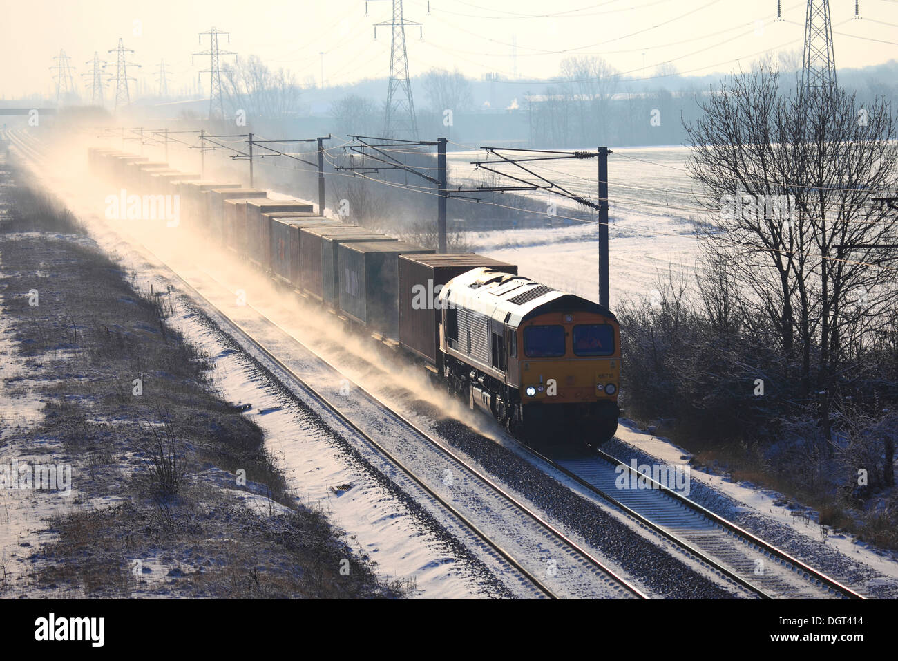 Winter Snow, GBFR Trains 66716 Diesel Freight Train, pulling containers, East Coast Main Line Railway, Cambridgeshire, England Stock Photo
