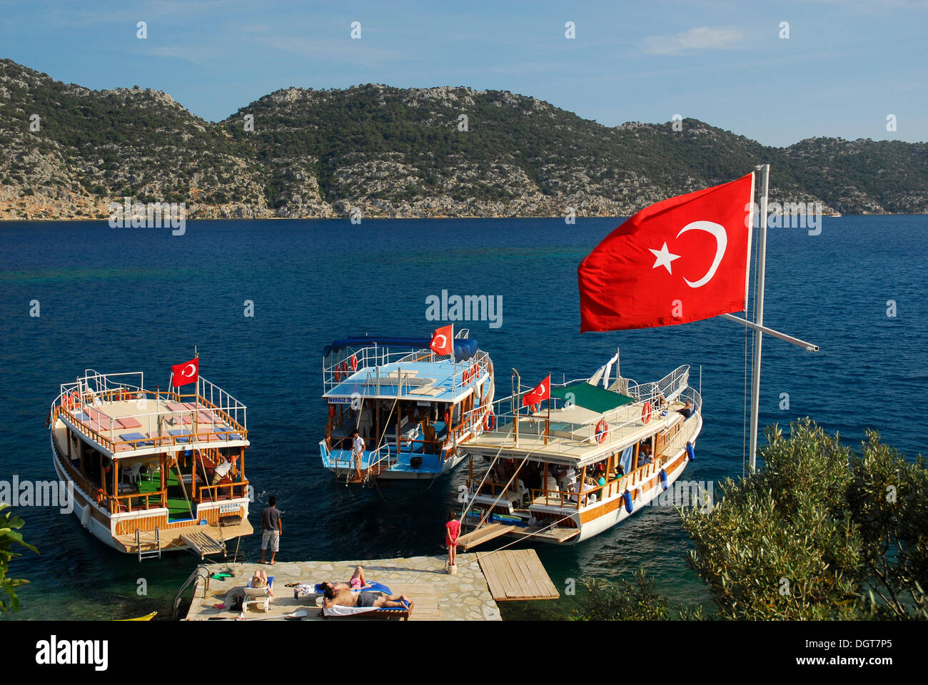 Turkish flag and boats on the quayside, village of Kale, Kalekoey or Simena, Kekova Bay, Lycian coast, Antalya Province Stock Photo