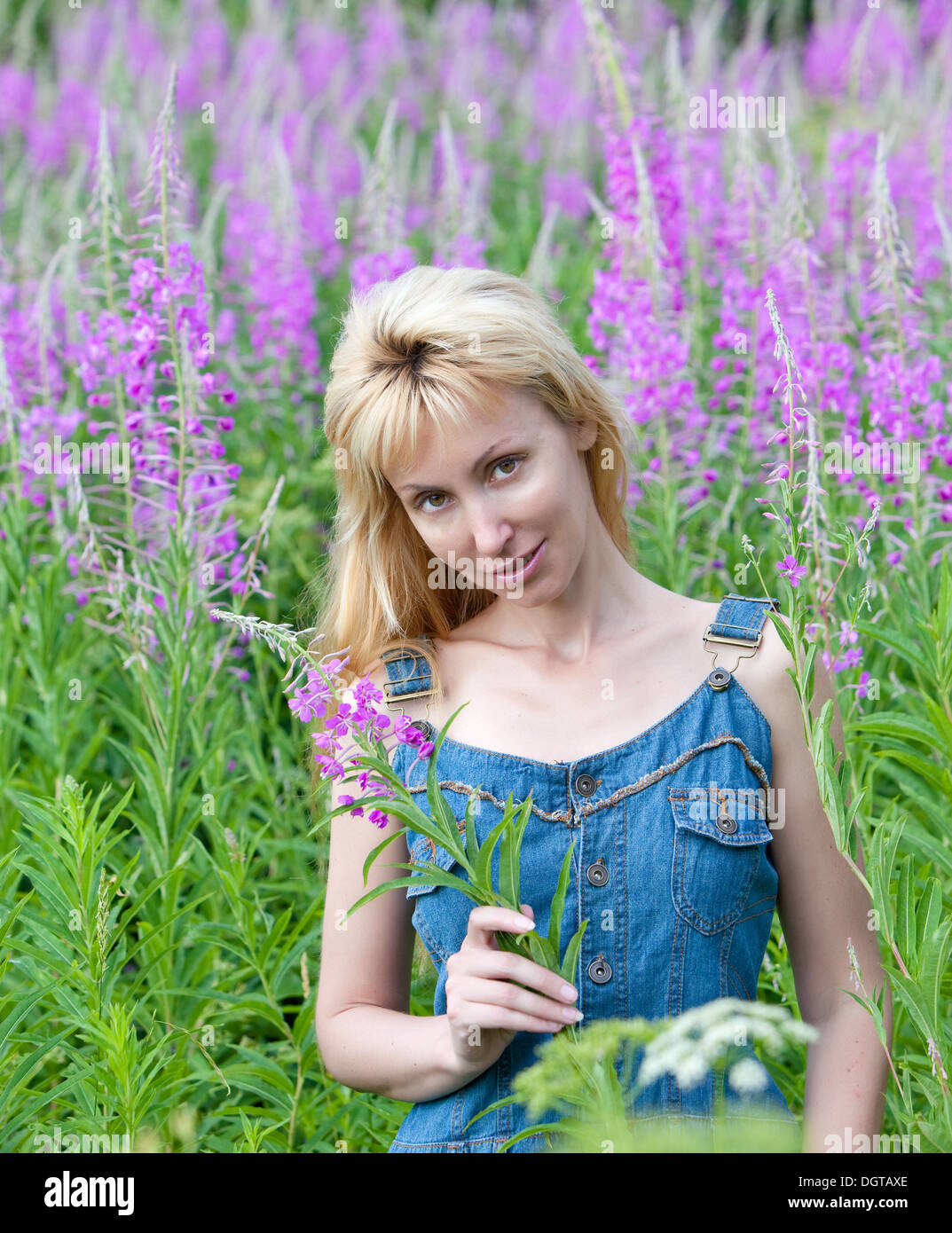 happy young woman in flowers blooming sally Stock Photo