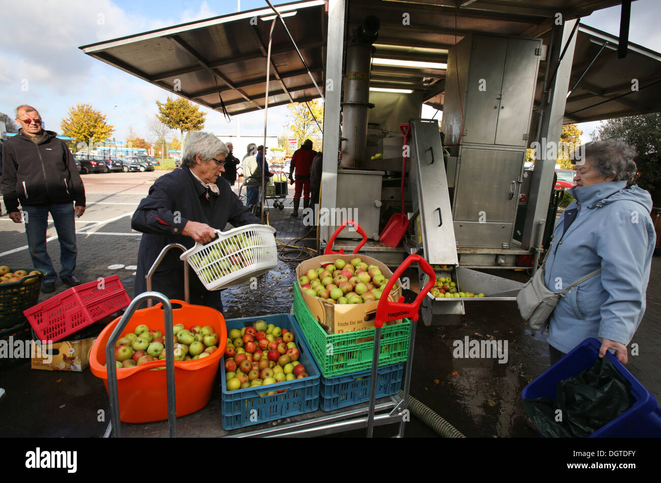 Rostock, Germany. 21st Oct, 2013. Customers bring fruit to the mobile apple-juice factory of the apple-juice factory Satow in Rostock, Germany, 21 October 2013. The facility which is moved to another town in the region every day can process up to 4,000 kilos a day. Photo: Bernd Wuestneck/ZB/dpa/Alamy Live News Stock Photo