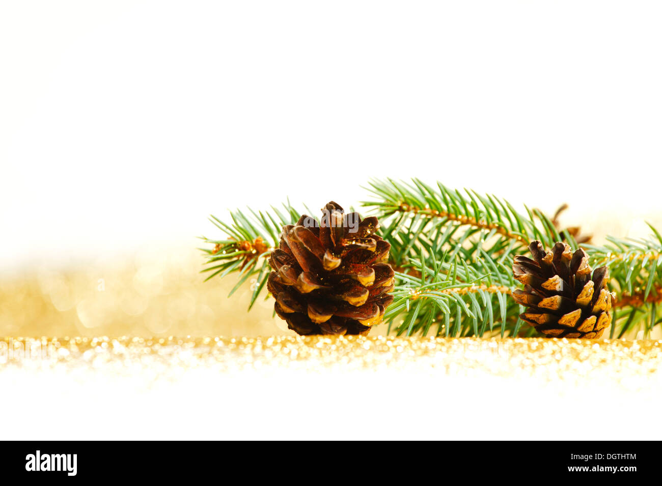 Pine cones and fir branch on golden glitter background Stock Photo - Alamy