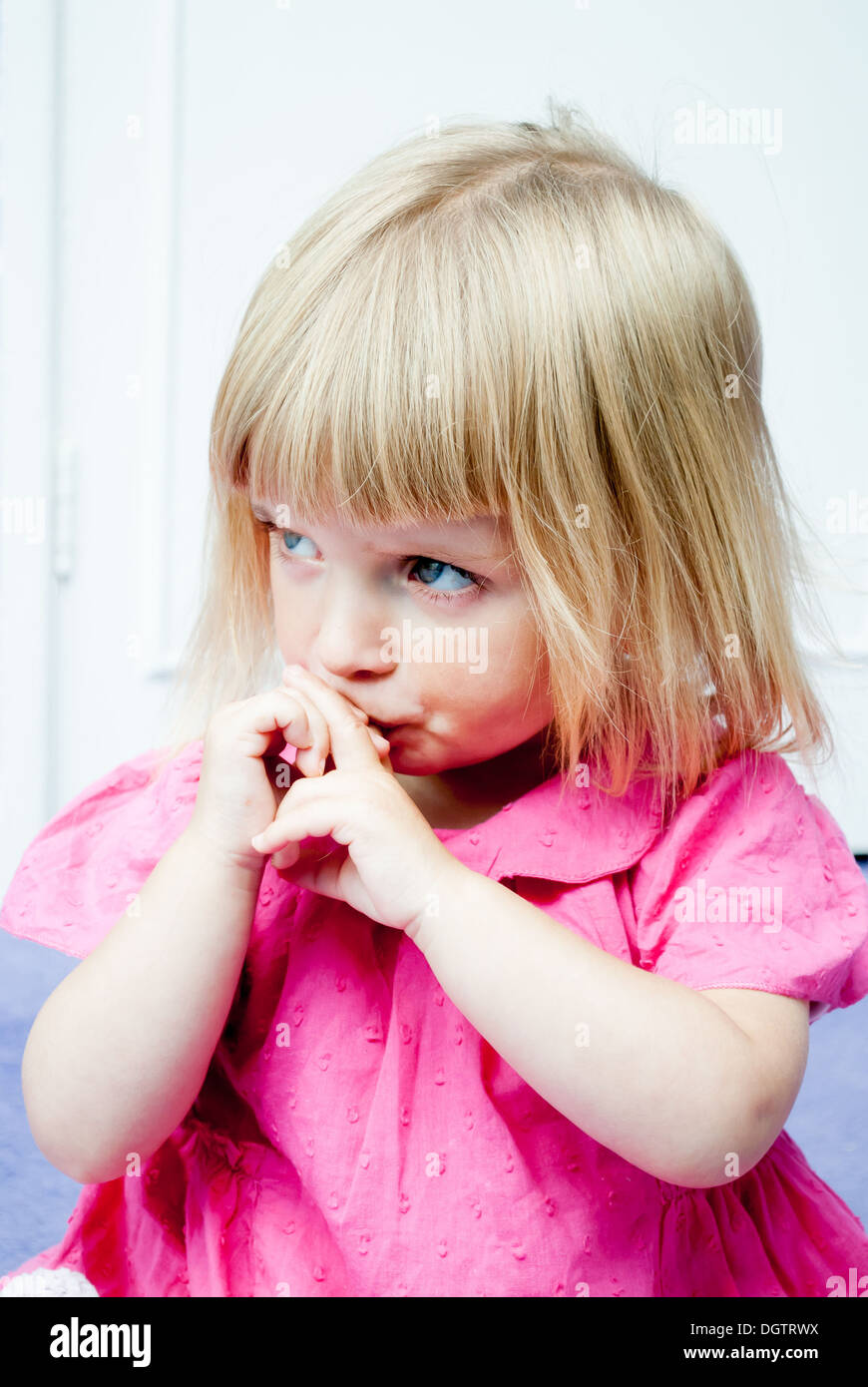 Unhappy little girl with her hands to her face. Stock Photo