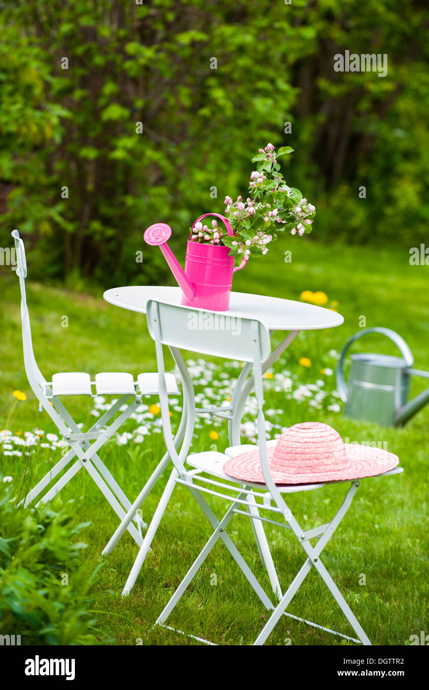 Garden table and chairs in a spring garden Stock Photo - Alamy
