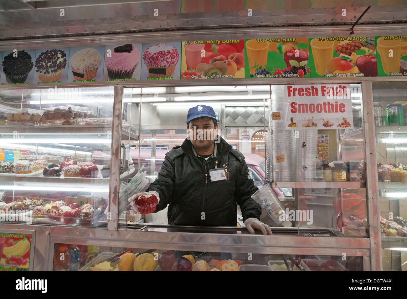A Vendor Holds A Cupcake For Sale At His Food Truck In New