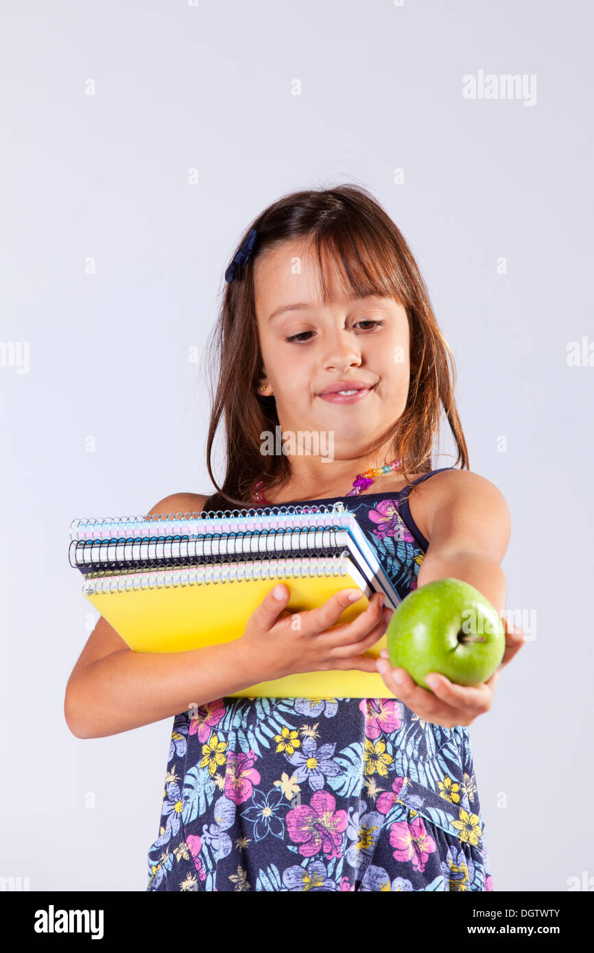 Little girl holding books and a apple ready to go to school Stock Photo ...
