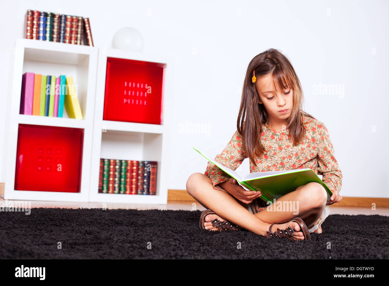 Little girl reading a book at home Stock Photo - Alamy