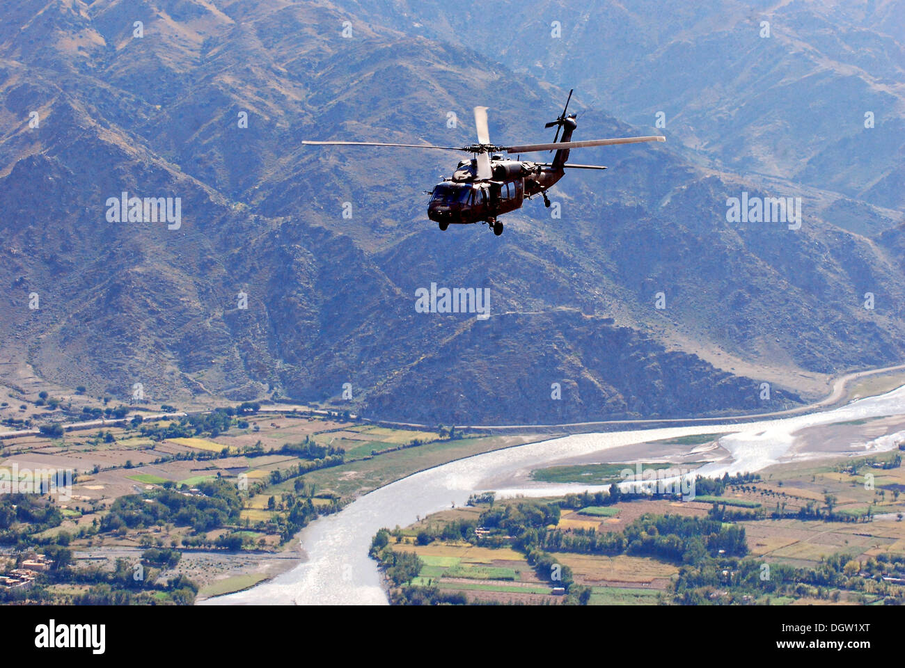 A U.S. Army UH-60L Black Hawk helicopter flies over a village October 17, 2013 in Kunar province, Afghanistan. Stock Photo