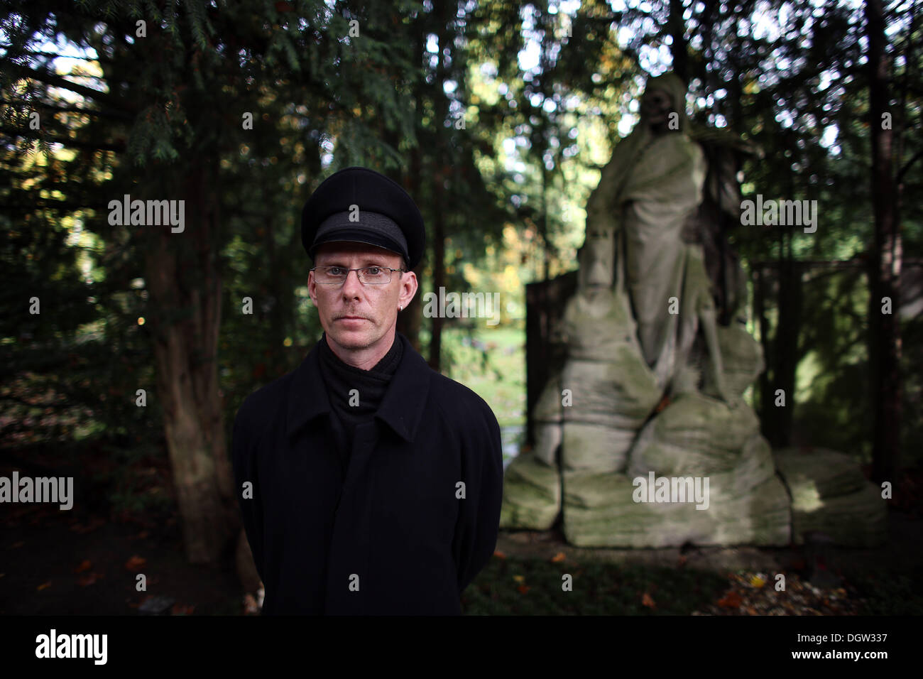 Cologne, Germany. 21st Oct, 2013. The Gravedigger Michael Roth stands in front of a grave with the 'Grim Reaper' on the Melatenfriedhof cemetery in Cologne, Germany, 21 October 2013. Photo: Oliver Berg/dpa/Alamy Live News Stock Photo