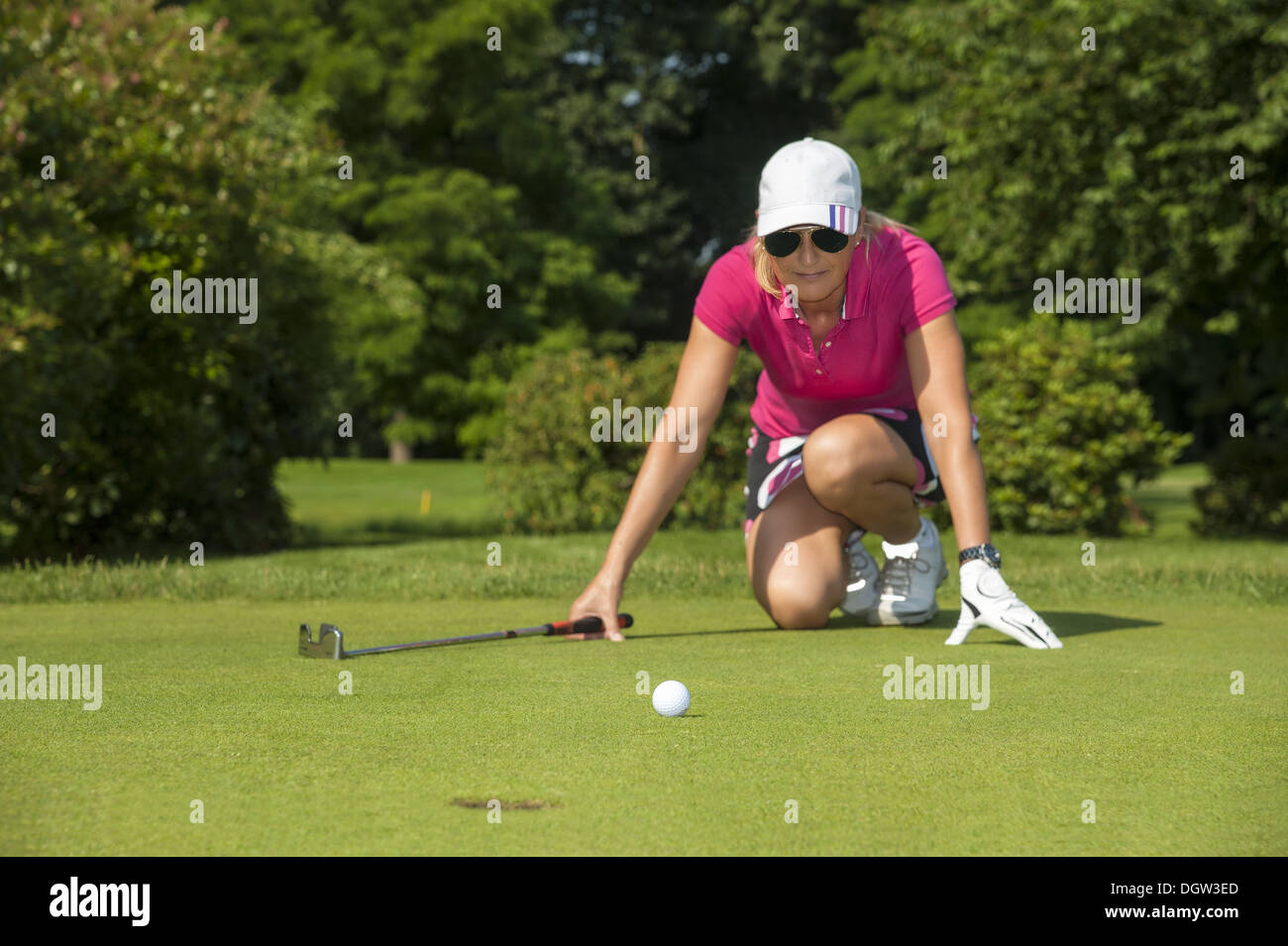 kneeling golfer Stock Photo