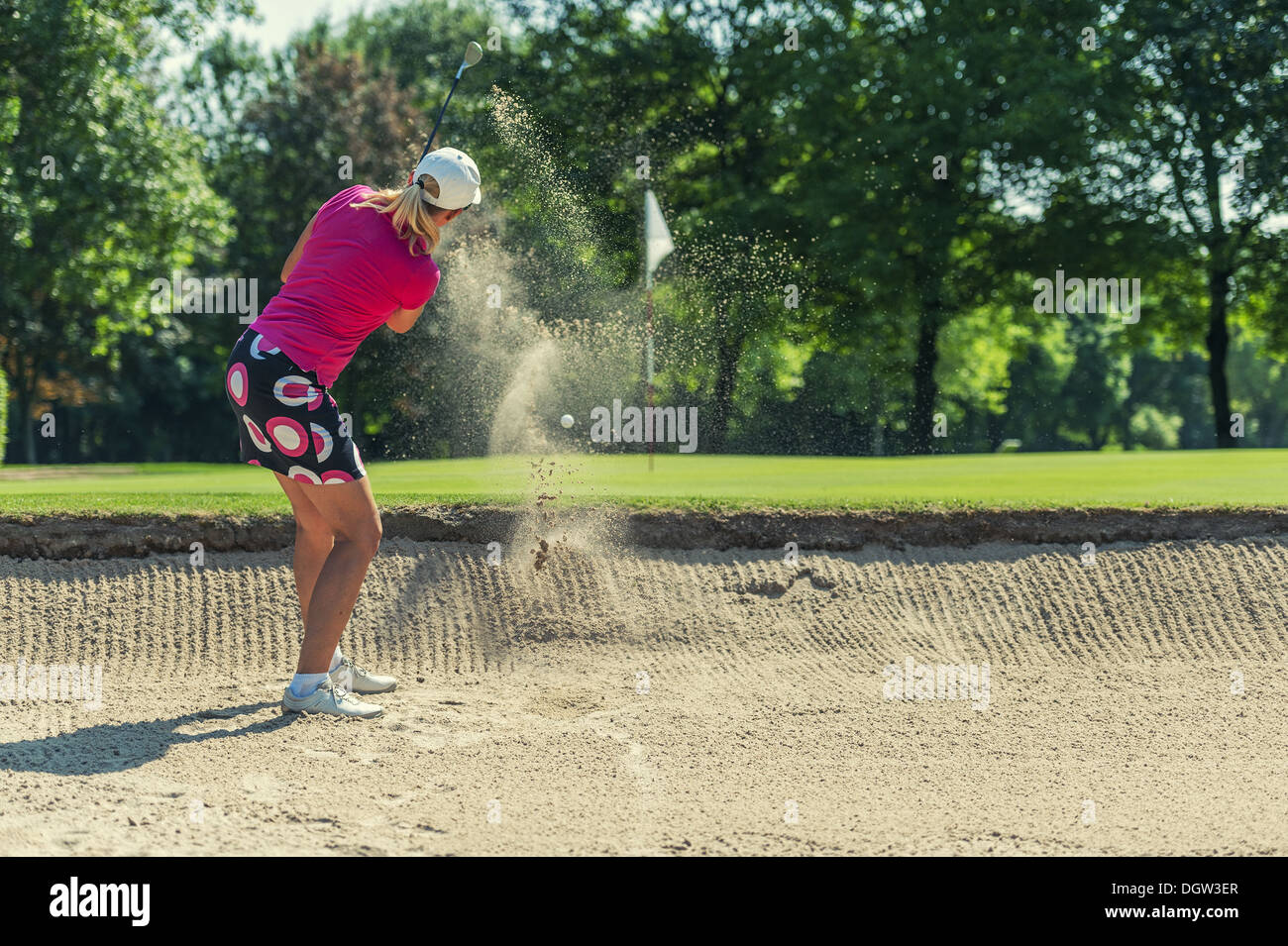 Golfer hitting the ball from the bunker Stock Photo