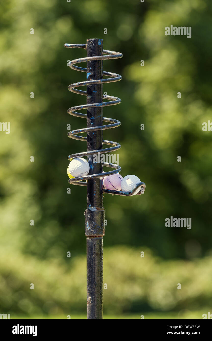Golf Balls on a metal spiral form a queue Stock Photo Alamy