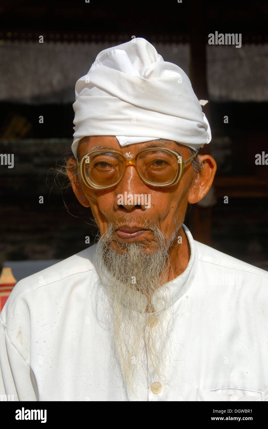 Bali Hinduism, portrait of an old Brahmin with white robe, glasses and a long beard, Pura Sadha Temple, Kapal, Bali, Indonesia Stock Photo