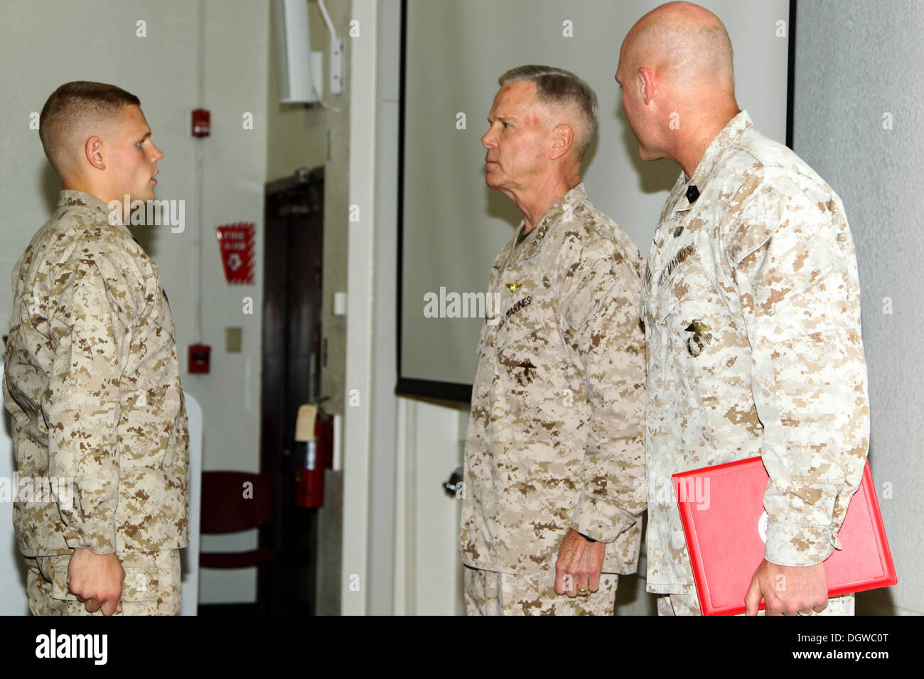 The 35th commandant of the Marine Corps, General James F. Amos, and the 17th sergeant major of the Marine Corps, Sgt. Maj. Micheal P. Barrett, promote Lance Cpl. Wesleigh M. Beckman, ordnance technician with Marine Aviation Logistics Squadron 11 (MALS-11) Stock Photo