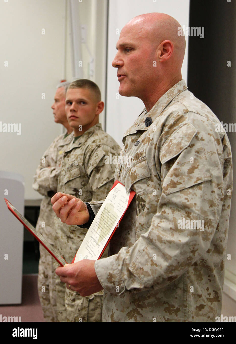 The 35th commandant of the Marine Corps, General James F. Amos, and the 17th sergeant major of the Marine Corps, Sgt. Maj. Micheal P. Barrett, promote Lance Cpl. Wesleigh M. Beckman, ordnance technician with Marine Aviation Logistics Squadron 11 (MALS-11) Stock Photo