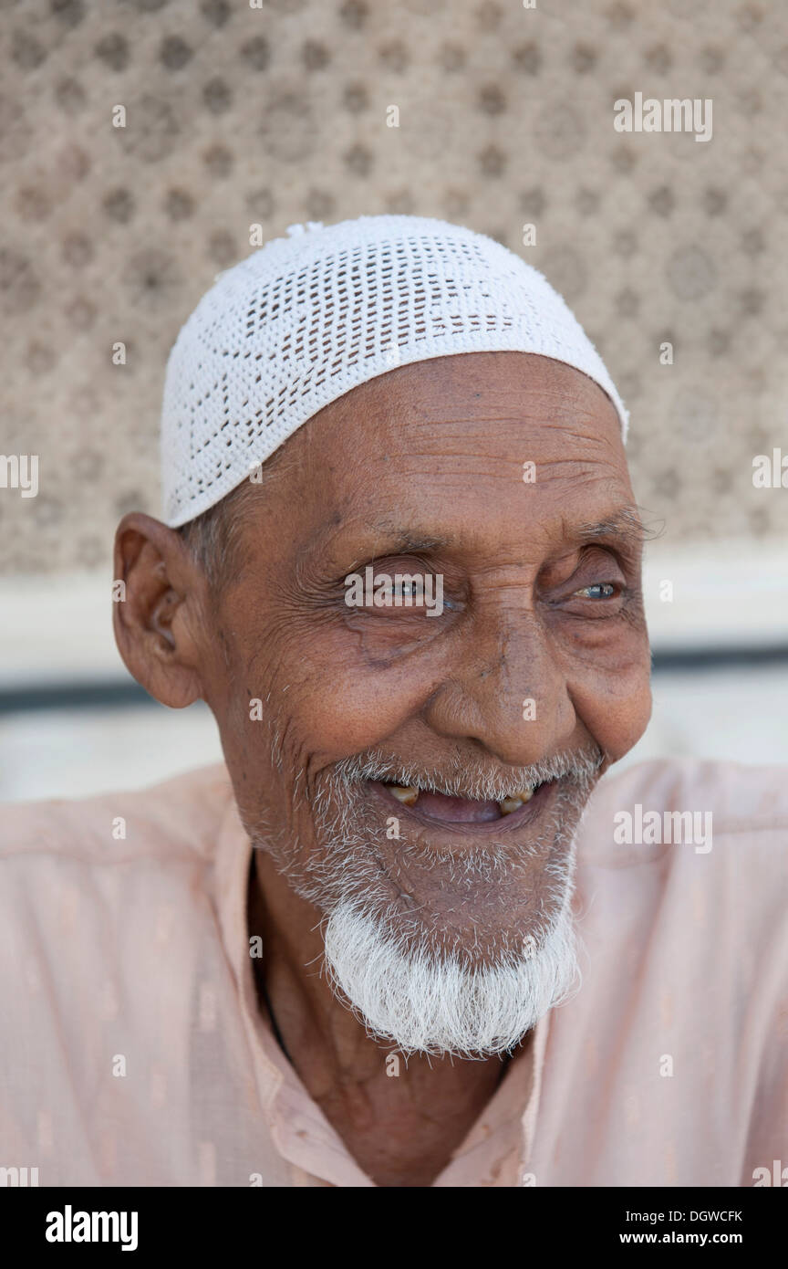 Islam, portrait, Muslim, old man with a beard wearing a cap, sitting in front of the Tomb of Sheikh Salim Chishti Stock Photo