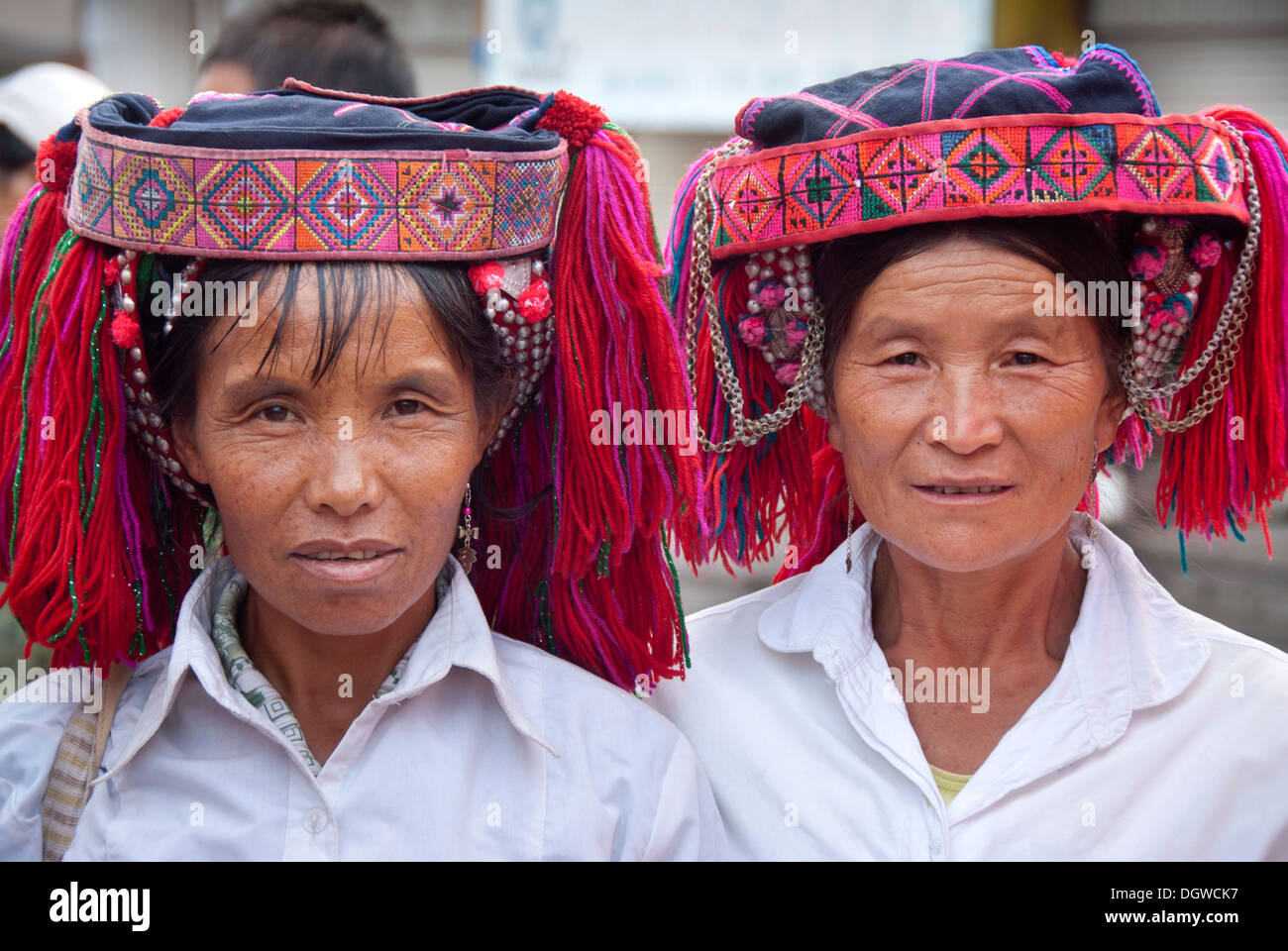 Two women of the Yi or Hani ethnic minority wearing colourful headware at a festival, portrait, Jiangcheng, Pu'er City Stock Photo