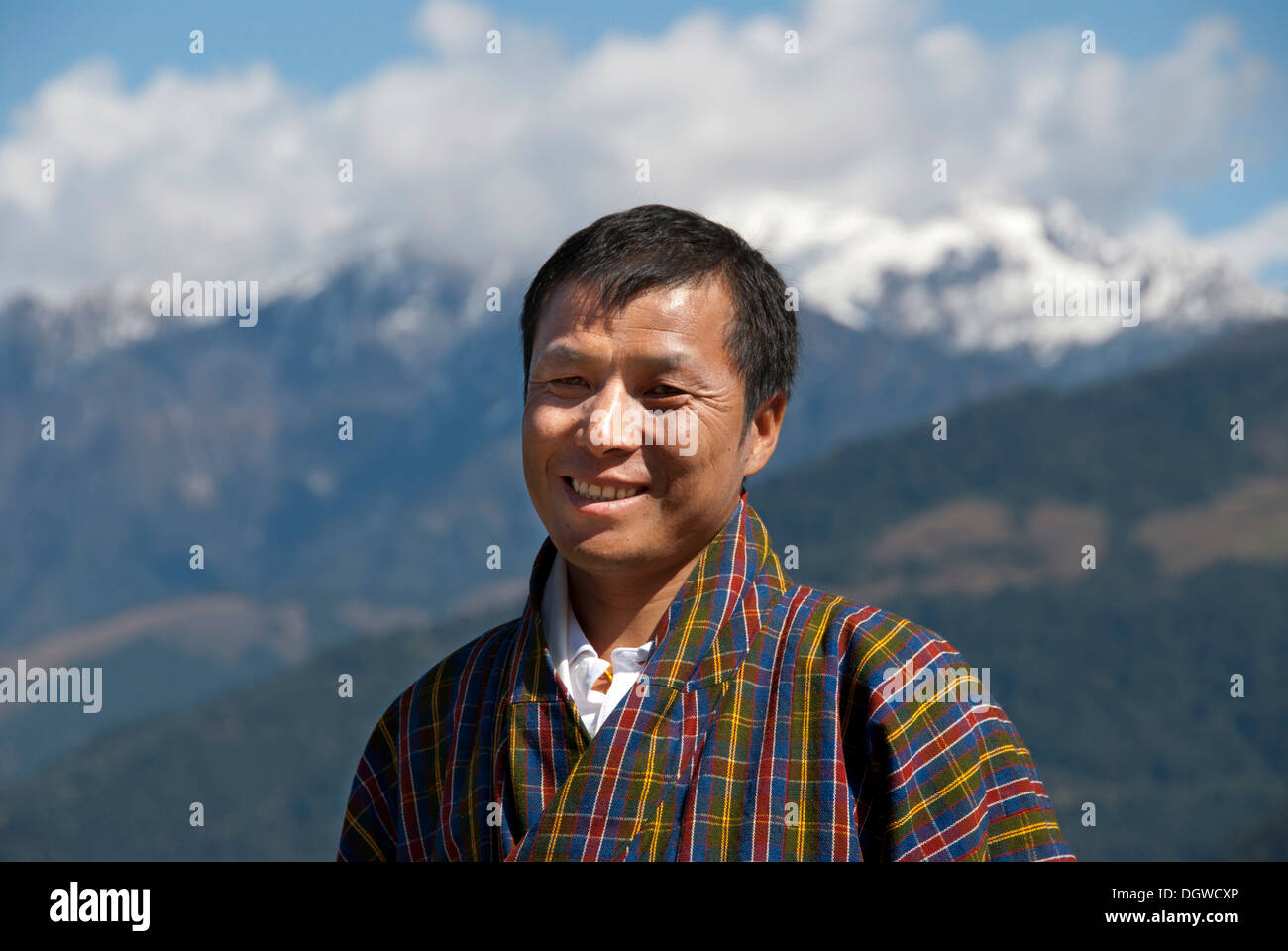 Man smiling, portrait, wearing traditional Gho dress, plaid fabric, the Himalayas, Bhutan, South Asia, Asia Stock Photo