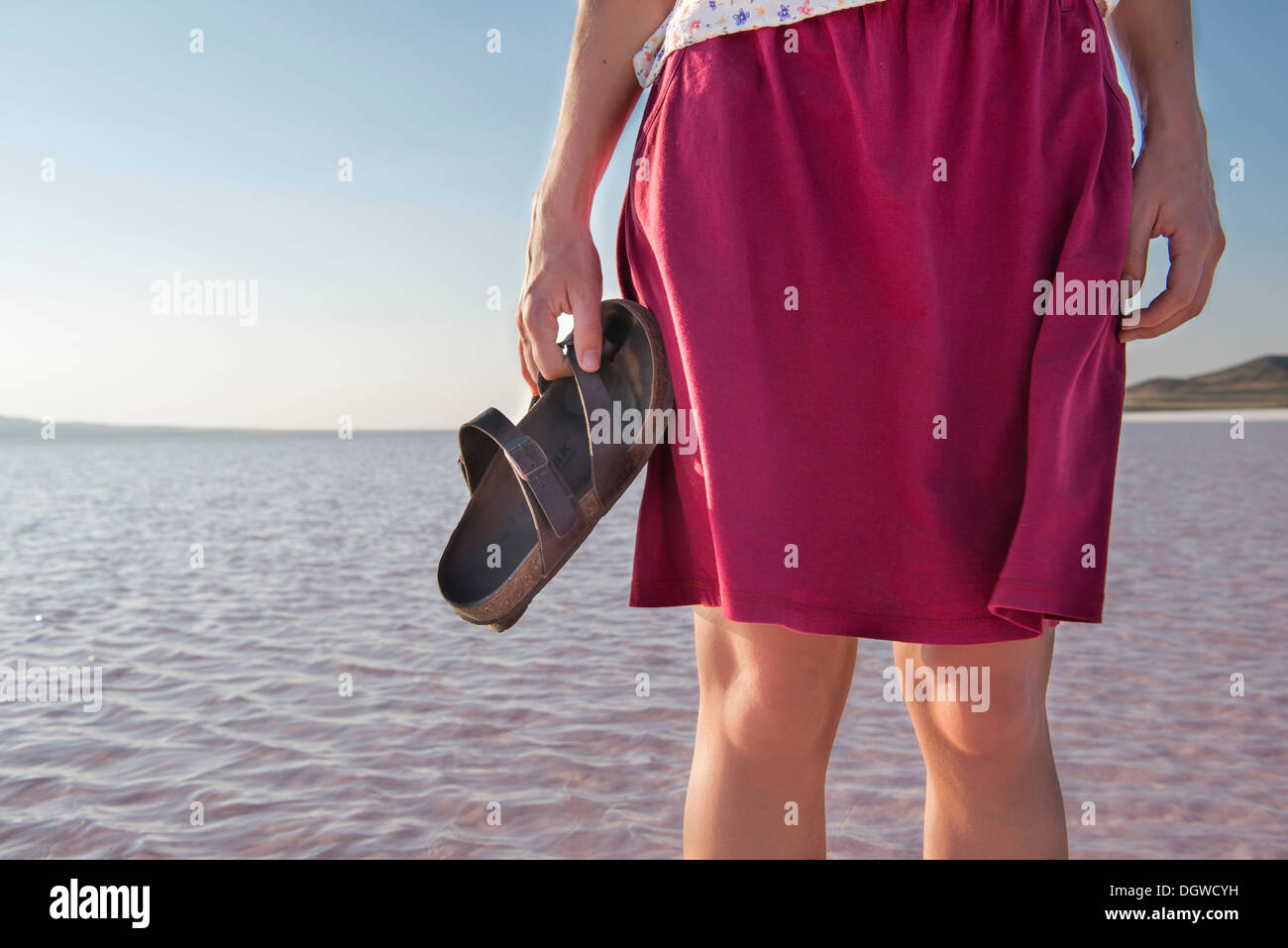 Woman standing in water with shoes off Stock Photo