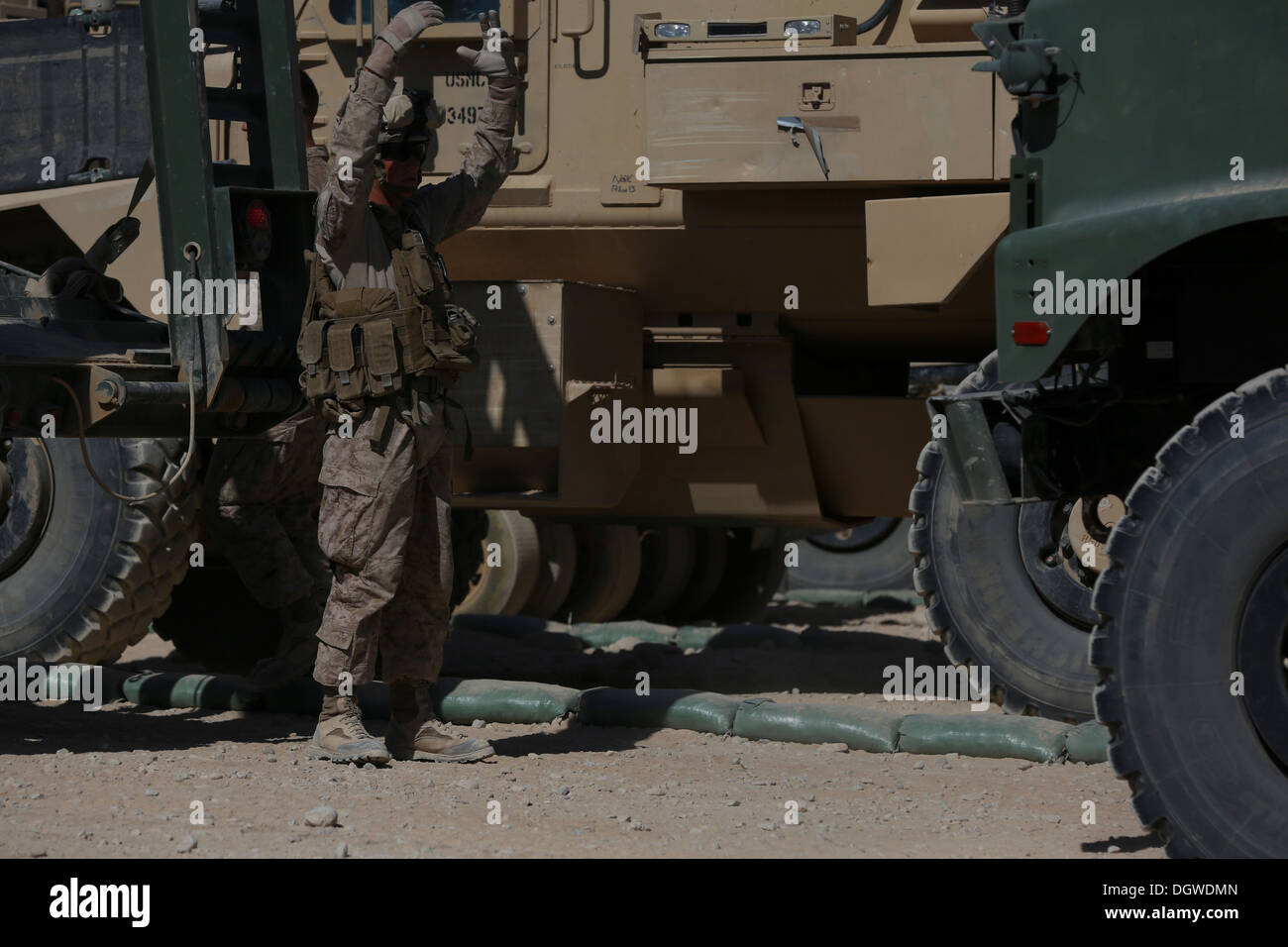 A U.S. Marine with Headquarters and Support Company, 1st Battalion, 9th Marine Regiment, ground guides a vehicle during a convoy at Patrol Base Boldak, Helmand province, Afghanistan, Oct. 18, 2013. The convoy was conducted to resupply PB Boldak. Stock Photo