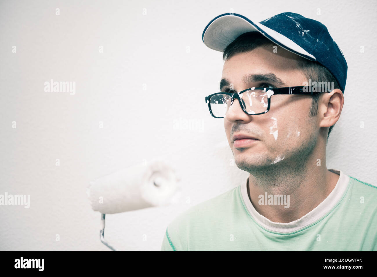 Young man decorating interior with paint roller. Stock Photo