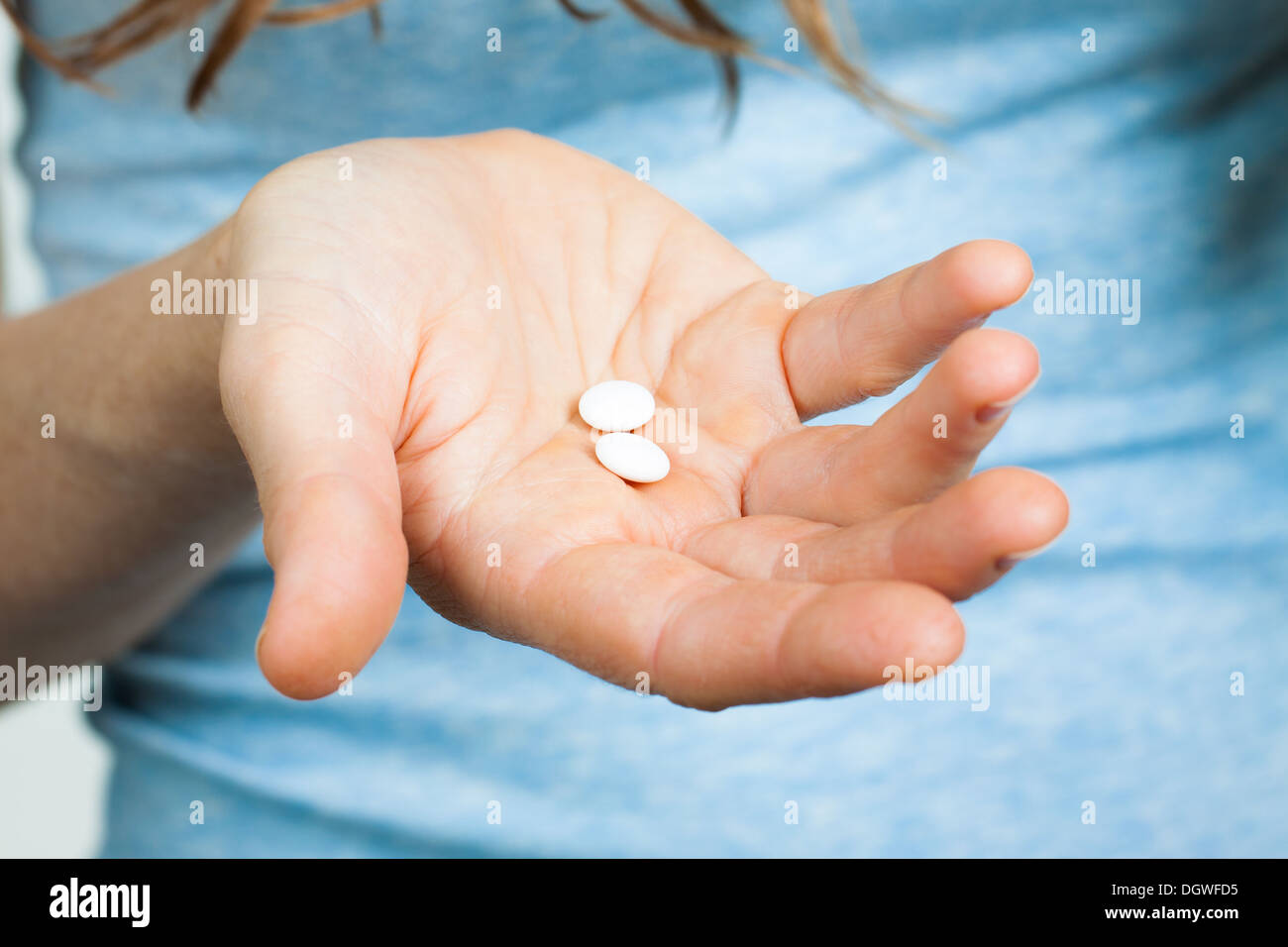 Close-up shot of a hand holding two white pills. Stock Photo