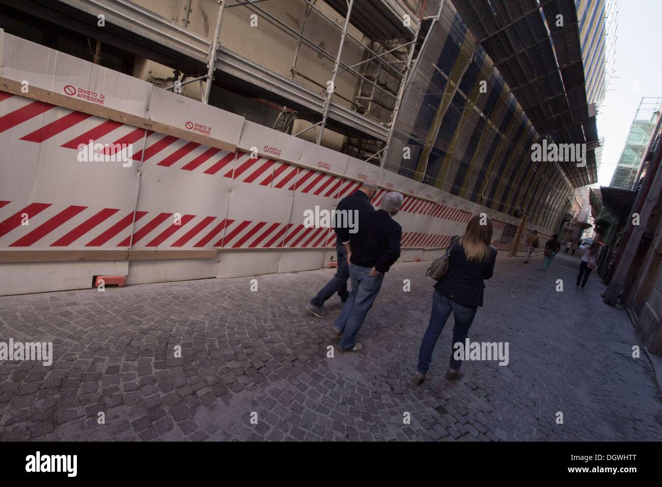 Oct. 26, 2013 - L'Aquila, Italy - People walk on October 25, 2013 in the historic area of LÌ¢??Aquila, destroyed by an earthquake four years ago, on April 6, 2009. Four years after, the historic center is still abandoned, the reconstruction process is slow outside of commercial premises and the city's churches and monuments are still covered in scaffolding.Photo: Manuel Romano/NurPhoto (Credit Image: © Manuel Romano/NurPhoto/ZUMAPRESS.com) Stock Photo