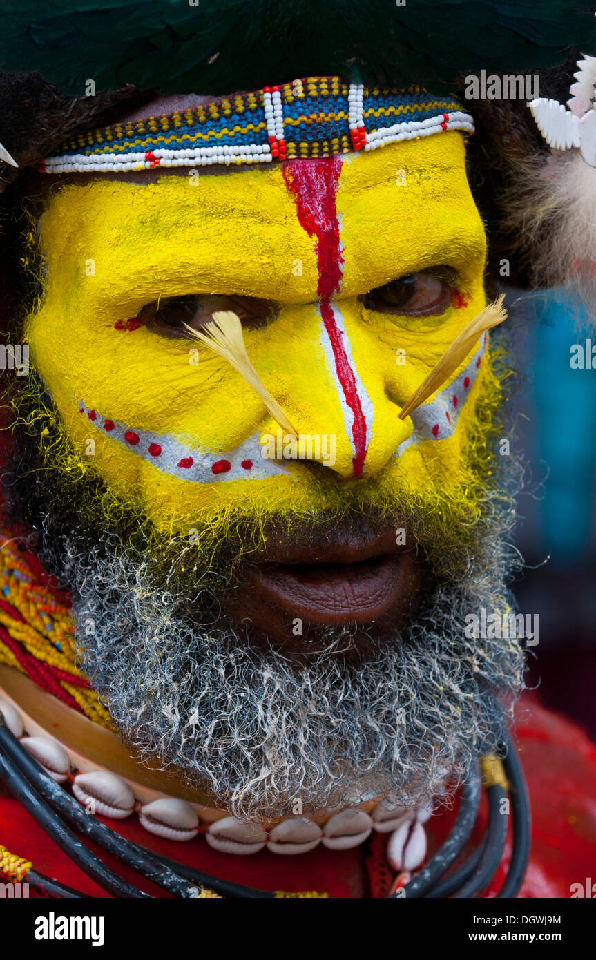 Man in a colourfully decorated costume with face paint is celebrating at the traditional Sing Sing gathering in the highlands Stock Photo