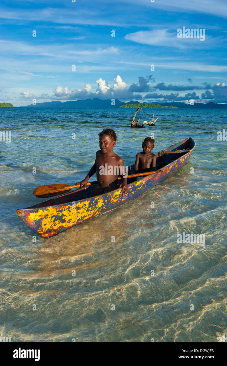 Boys in a canoe in the Marovo Lagoon, Marovo Lagoon, Western Province, Solomon Islands Stock Photo