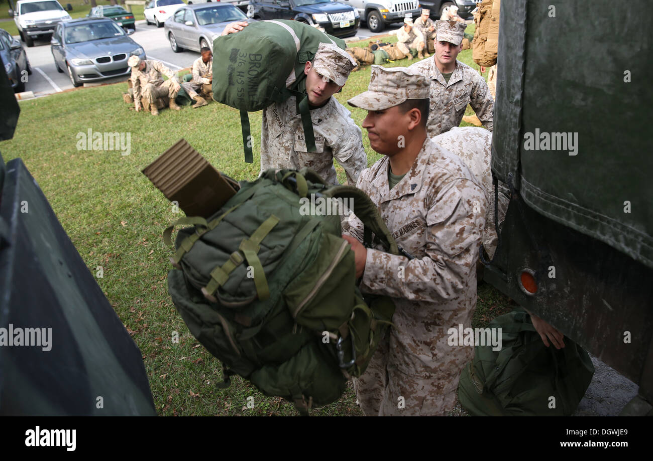 Marines with India Company, 3rd Battalion, 6th Marine Regiment, 2nd Marine Division, load their gear onto 7-ton trucks aboard Marine Corps Base Camp Lejeune, N.C. Oct. 18, 2013. Third Bn., 6th Marines recently conducted an activation and personnel movemen Stock Photo