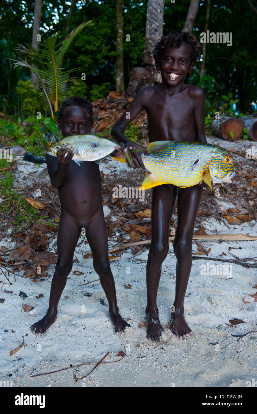 Boys proudly showing the fish they caught, Marovo Lagoon, Western Province, Solomon Islands Stock Photo