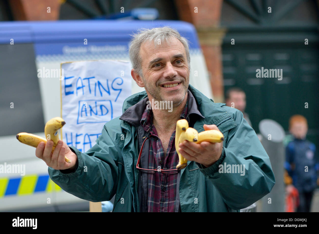 Manchester, UK. 26th Oct, 2013. A protester hands out bananas to show the displeasure of a small anti-Coalition Government group protesting against the bedroom tax and government measures, which are making the life of the ordinary citizen worse than before.  Credit:  John Fryer/Alamy Live News Stock Photo