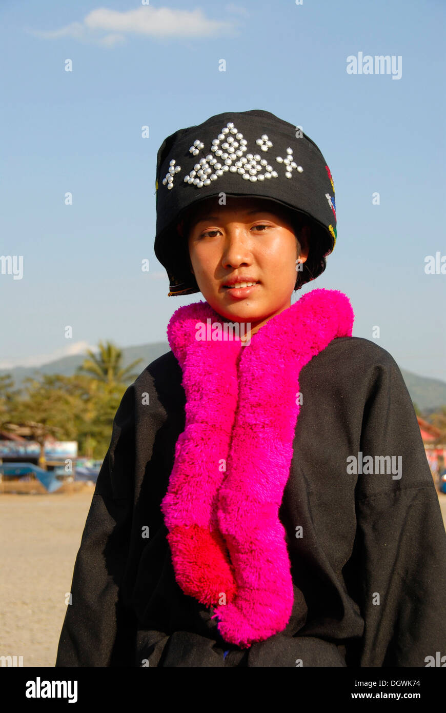 Portrait of a young woman of the Yao ethnic group, Mien, in traditional costume, traditional hat, pink woolen scarf, Vang Vieng Stock Photo