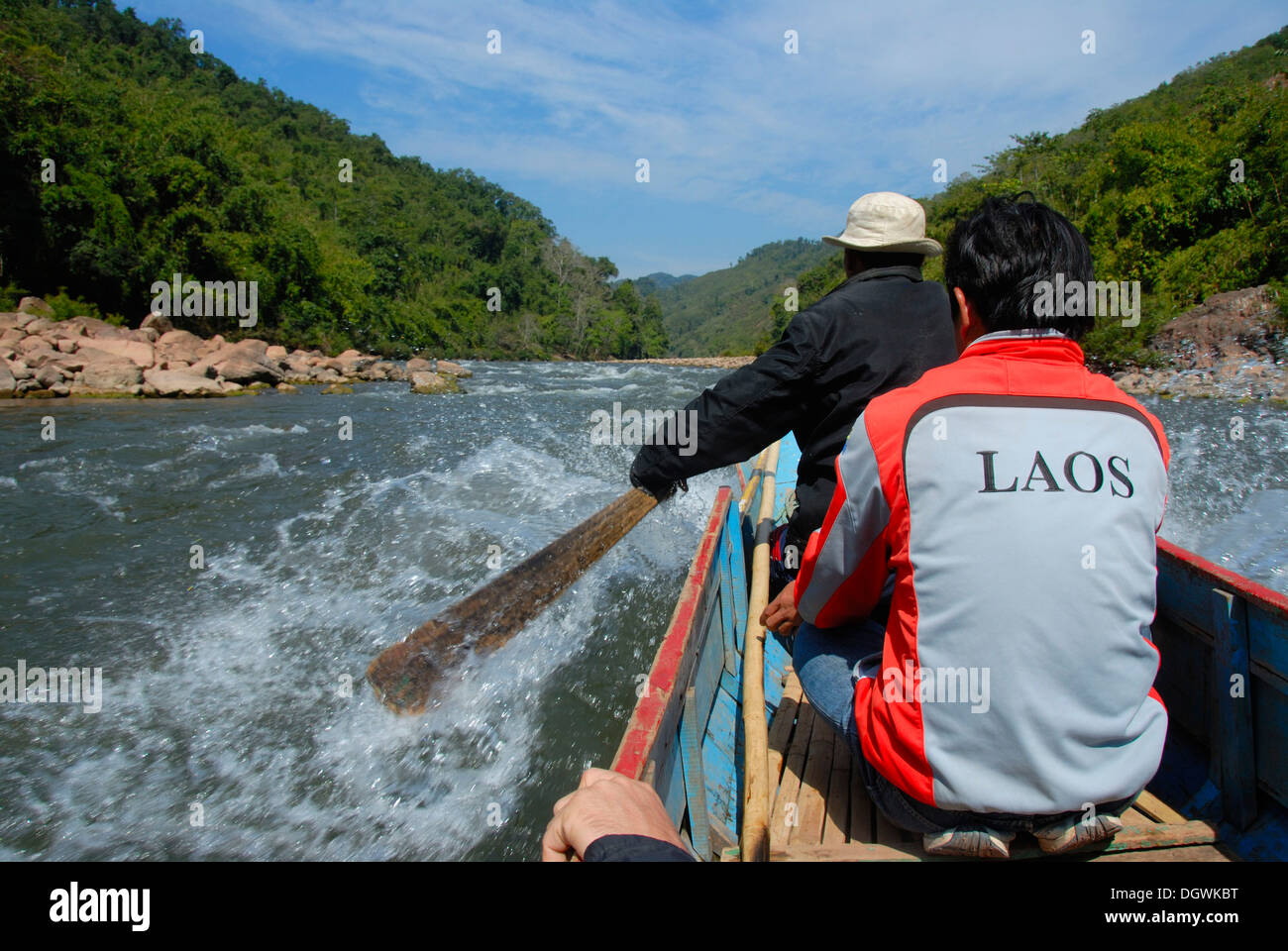 Wooden boat with a paddle going upstream the Nam Ou River, wild river, at Hathinh, Phou Den Din National Protected Area Stock Photo