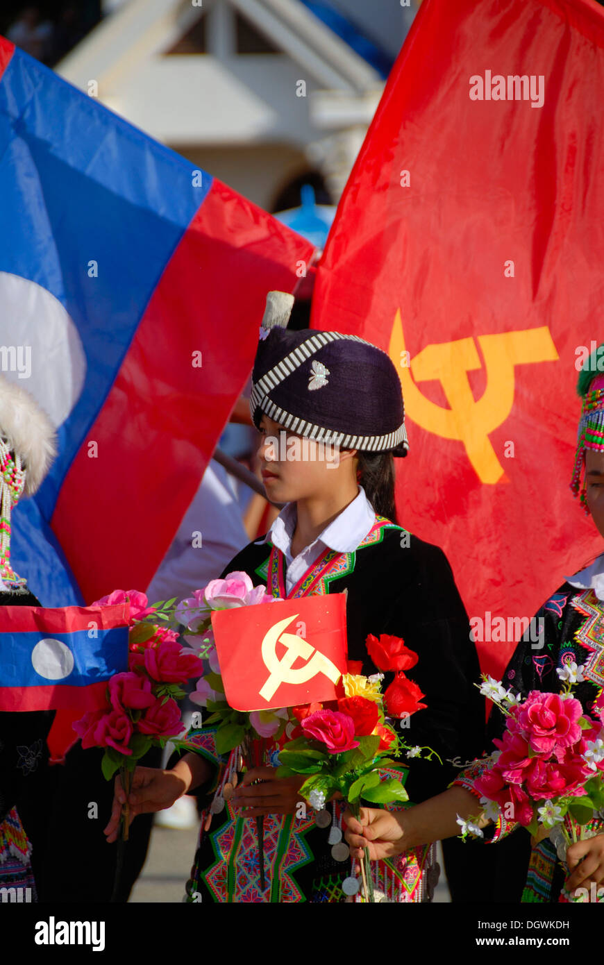 Girl of the Hmong ethnic group, traditional clothes with turban, Lao national flag, flag of the Communist Party, Xam Neua Stock Photo