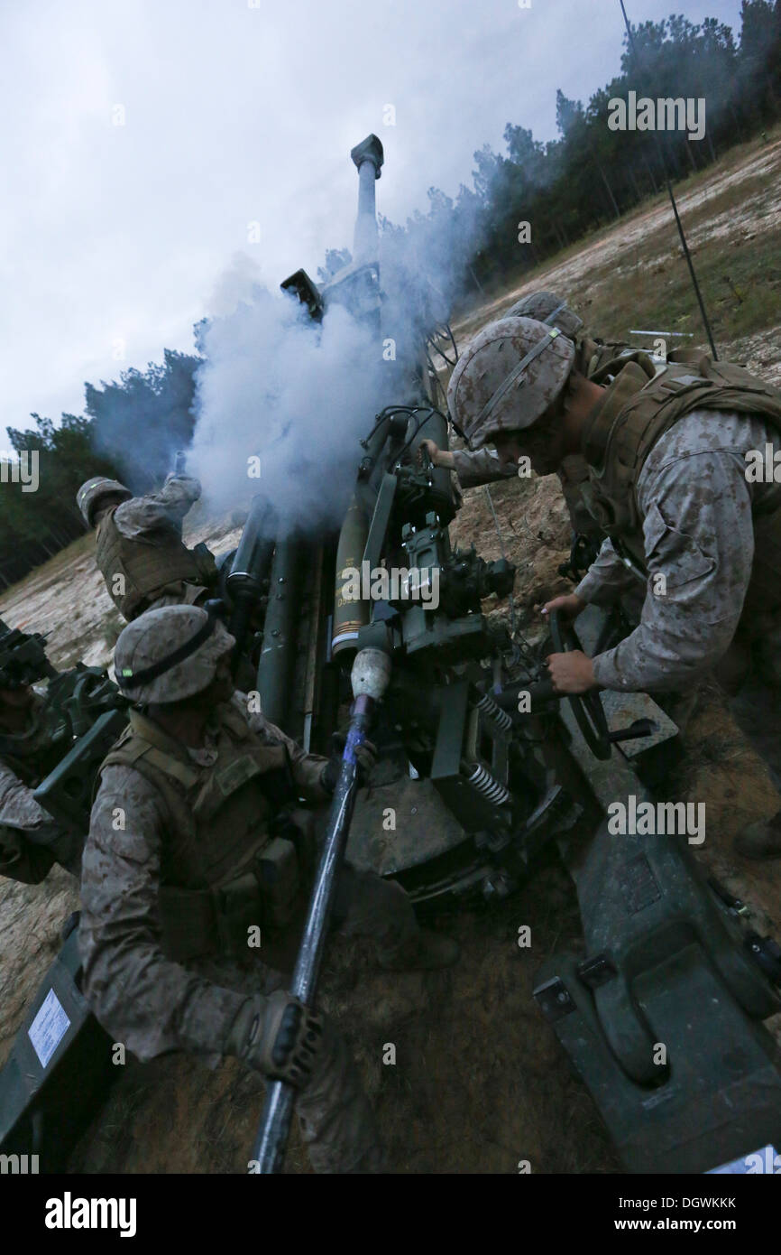 U.S. Marine Corps Pfc. Daniel Nunez, cannoneer position five, India Battery, 3rd Battalion, 10th Marines, places the ramming staff behind a high explosive round to be inserted into an M777 Howitzer during Operation Rolling Thunder aboard Ft. Bragg, N.C., Stock Photo
