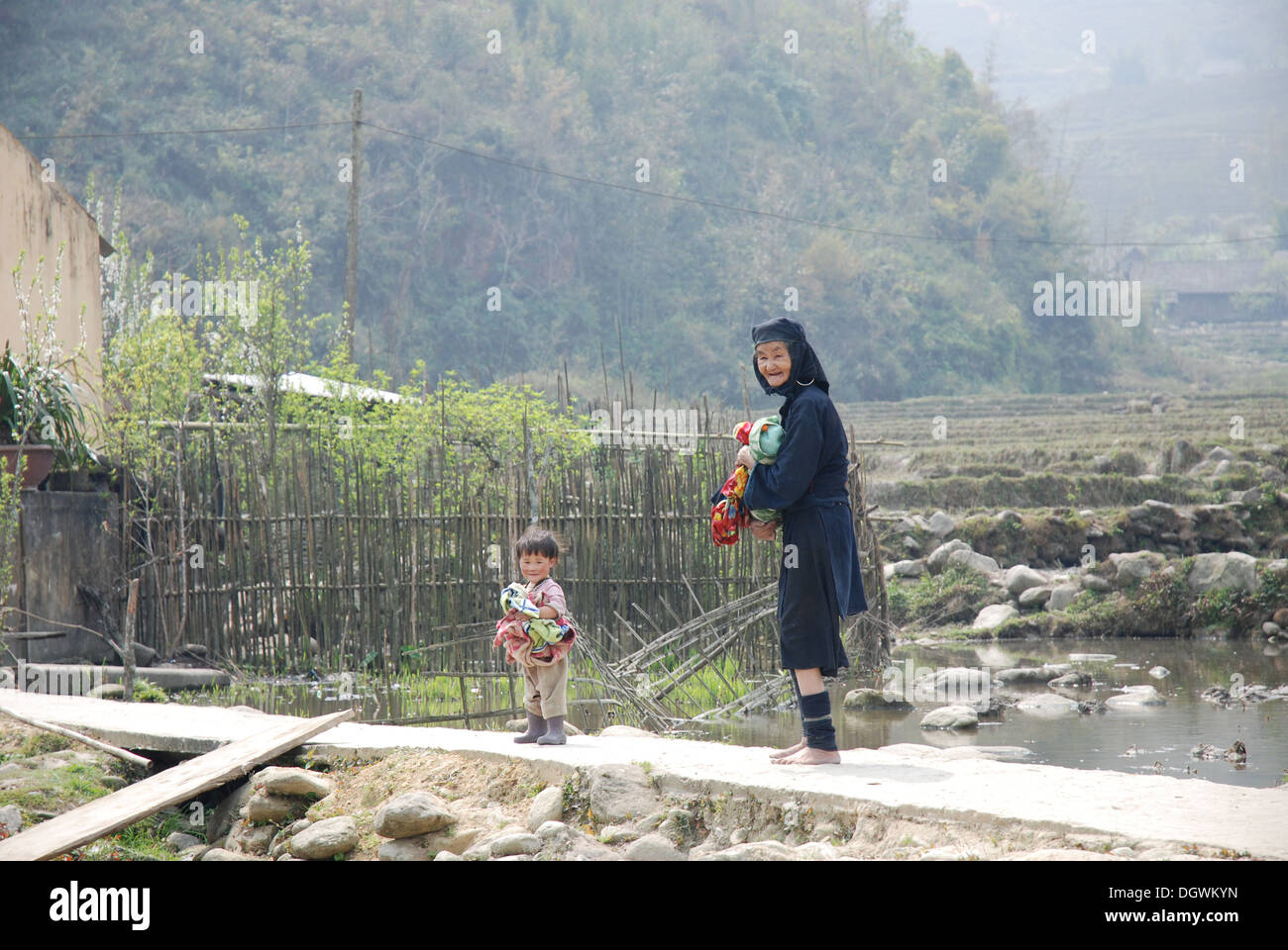 Black hmong tribes woman doing the laundry with a child helper in Cat Cat village, near Sapa in Vietnam Stock Photo