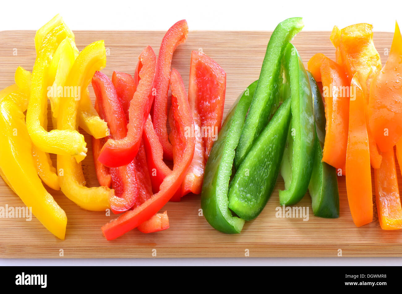 Sliced red, orange,green and yellow bell peppers ready for stir fry, appetizer, or salad Stock Photo