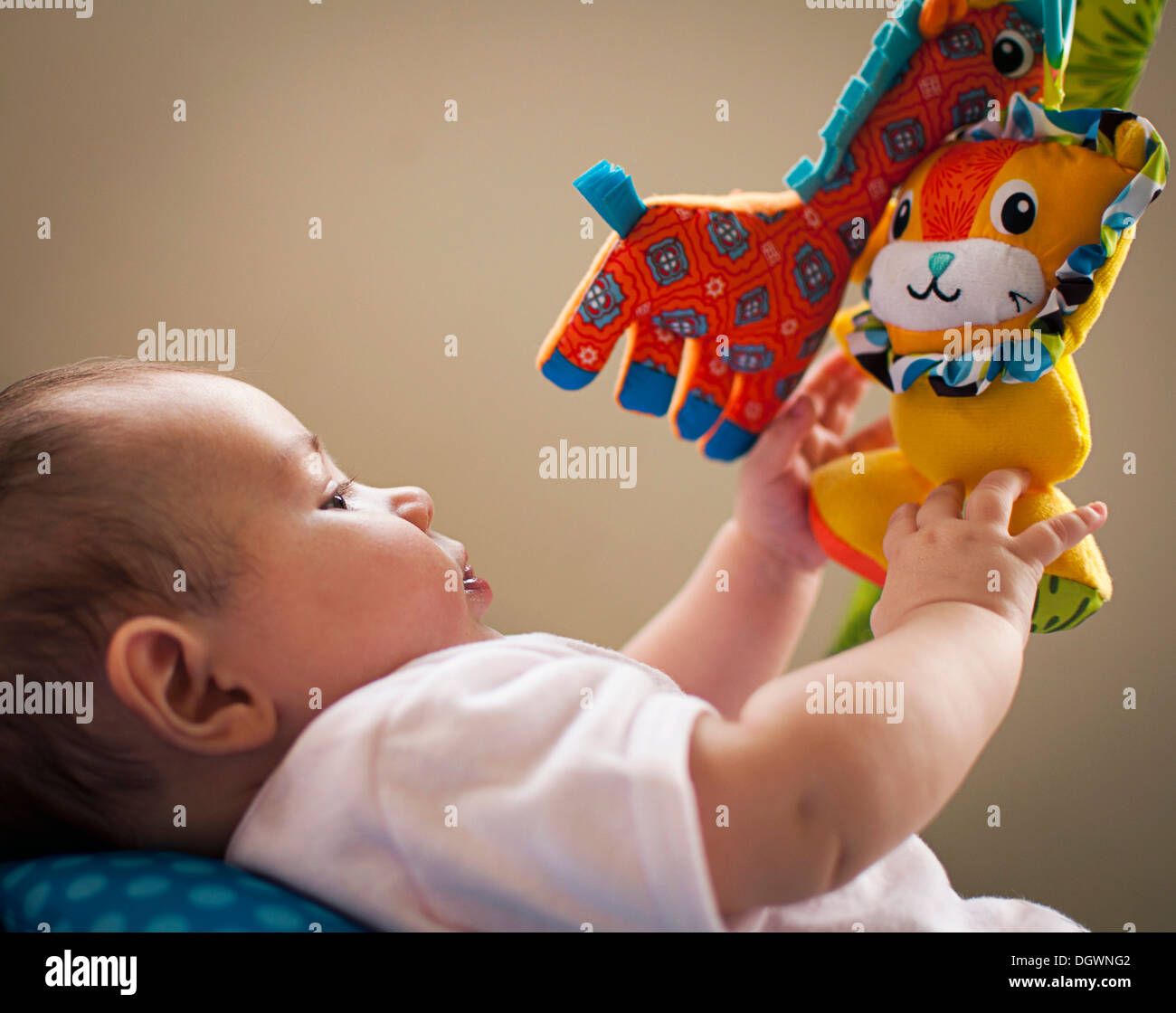 Baby girl playing with mobile toys Stock Photo