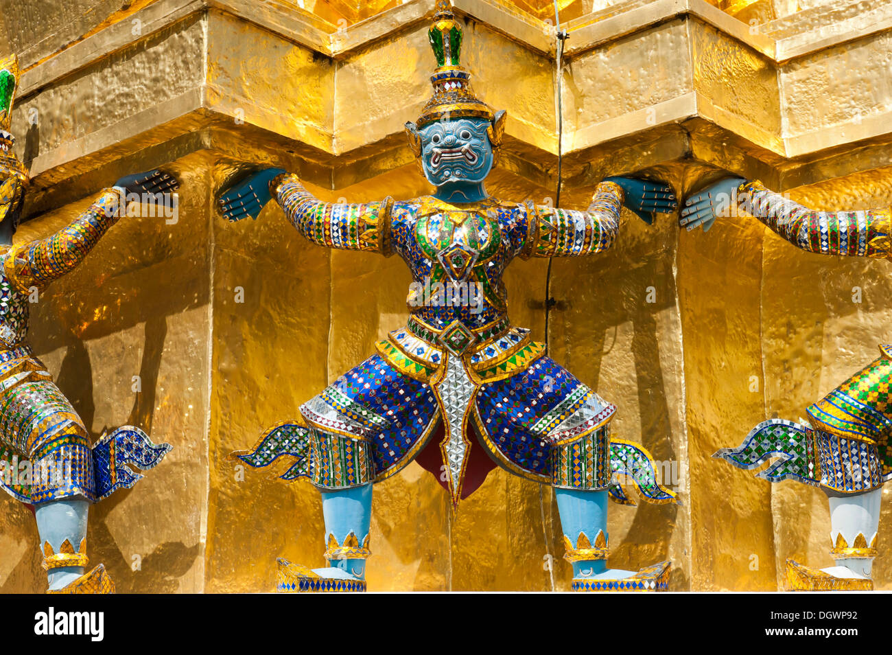 Guardian statue at the base of a golden chedi, Wat Phra Kaeo or Wat Phra Kaew Temple, Royal Palace, Großer Palast, Grand Palace Stock Photo