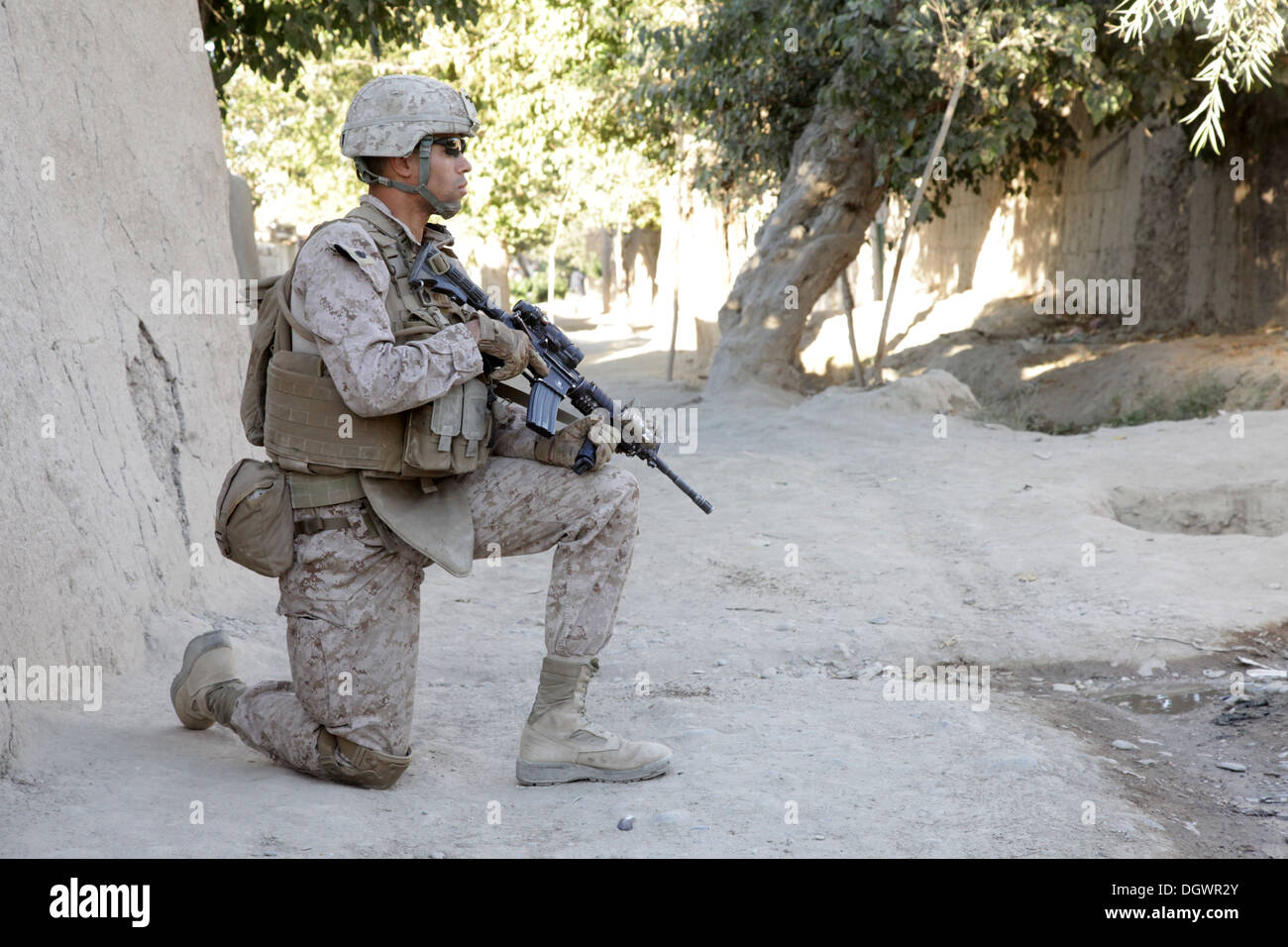 U.S. Marine Corps Staff Sgt. Derrick Warren, a platoon sergeant with India Company, 3rd Battalion, 7th Marine Regiment, kneels during a patrol near Forward Operating Base Musa Qala, Helmand province, Afghanistan, Oct. 20, 2013. The Marines with 3/7 patrol Stock Photo
