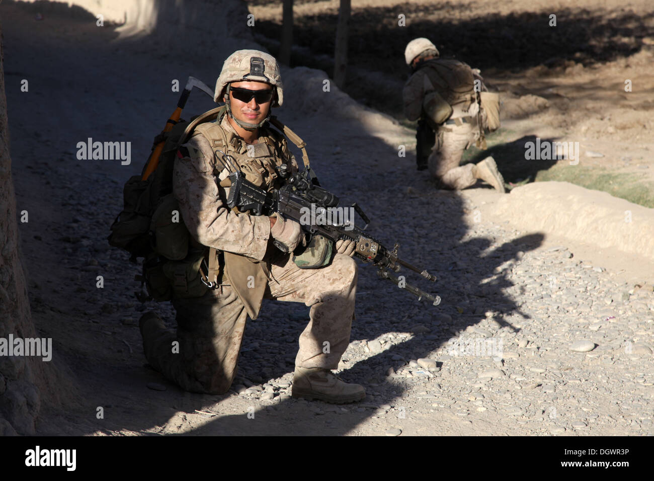 U.S. Marine Corps Lance Cpl. Marco Baro, a rifleman with India Company, 3rd Battalion, 7th Marine Regiment, kneels during a patrol near Forward Operating Base Musa Qala, Helmand province, Afghanistan, Oct. 20, 2013. The Marines with 3/7 patrolled to reduc Stock Photo