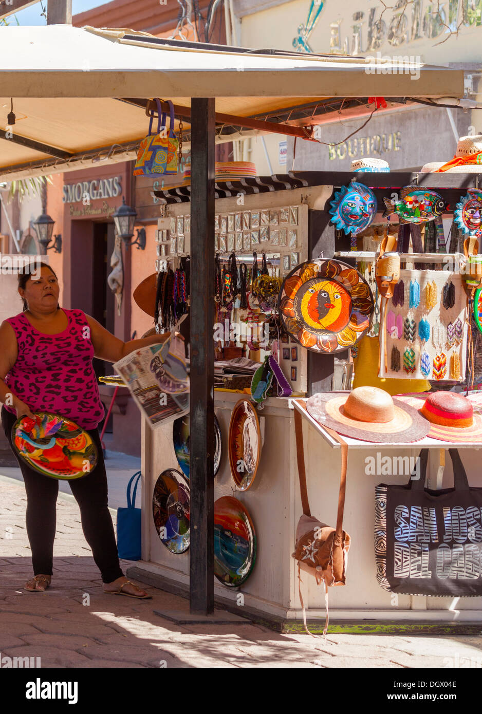 A stallholder puts the finishing touches to her souvenir stall in central Cabo San Lucas, Baja California Sur, Mexico Stock Photo