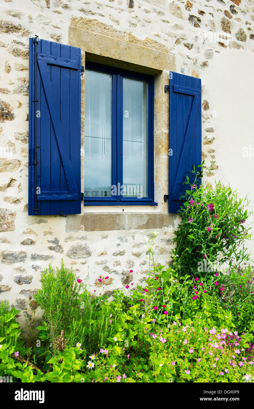 french-window-with-blue-shutters-and-flower-garden-outdoor-stock-photo