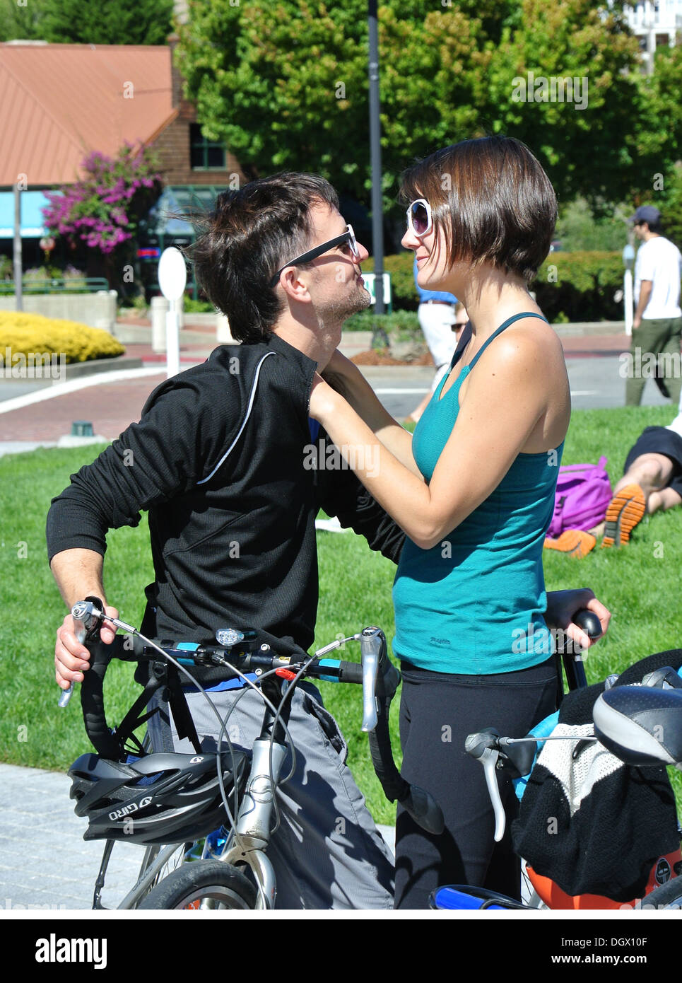 couple on bikes hugging and looking at each other at Tiburon ferry Stock Photo