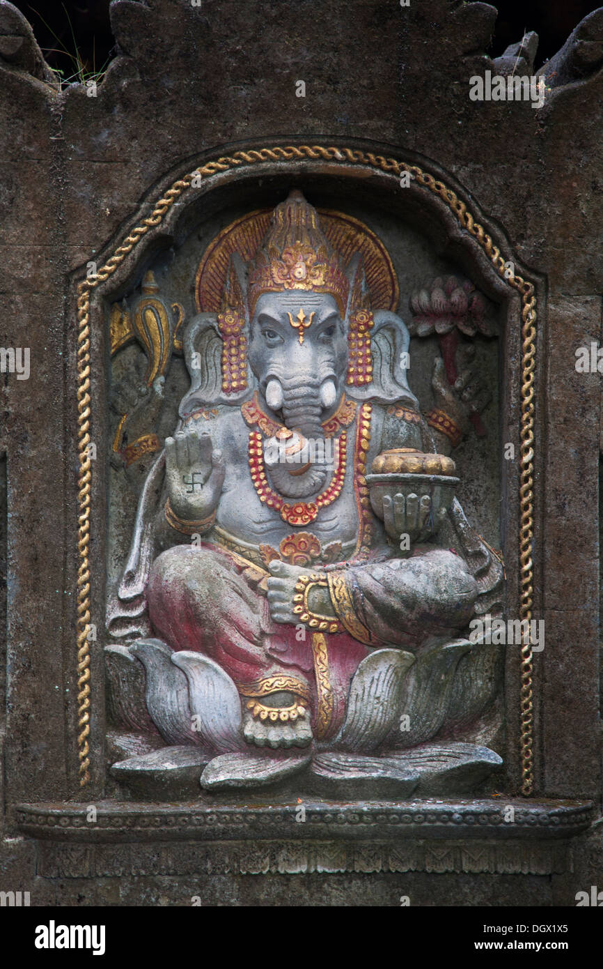 Ganesha hinduism god Bali elephant sculpture wall curve curving engraving color sit spirit religion religious frame depth Asia Stock Photo