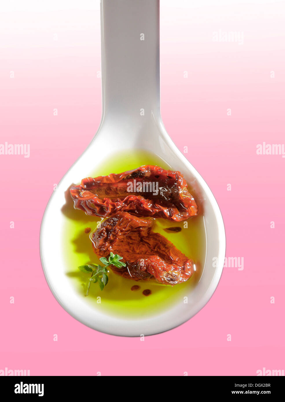 Dried tomatoes in olive oil on a white spoon Stock Photo