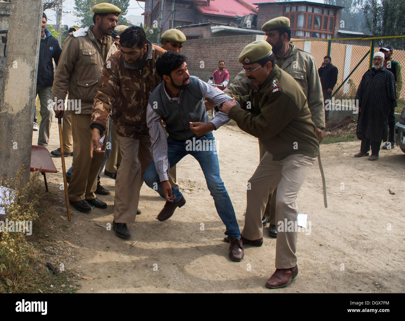 Srinagar, Indian Administered Kashmir 27 october 2013. An Indian policeman arrests a supporter of Shabir Ahmad Shah a separatist leader  during an Indian protest in Srinagar the summer capital of indian adminstered kashmir ,india . Large number of Indian troops were deployed to thwart anti-Indian protests in Kashmir. Indian troops landed in Kashmir  on  27 October  in kashmir  in 1947 A shutdown called by many resistance groups against the landing of the Indian army in Jammu and Kashmir this day in 1947 is being observed on Sunday.. (Sofi Suhail/ Alamy Live News) Stock Photo