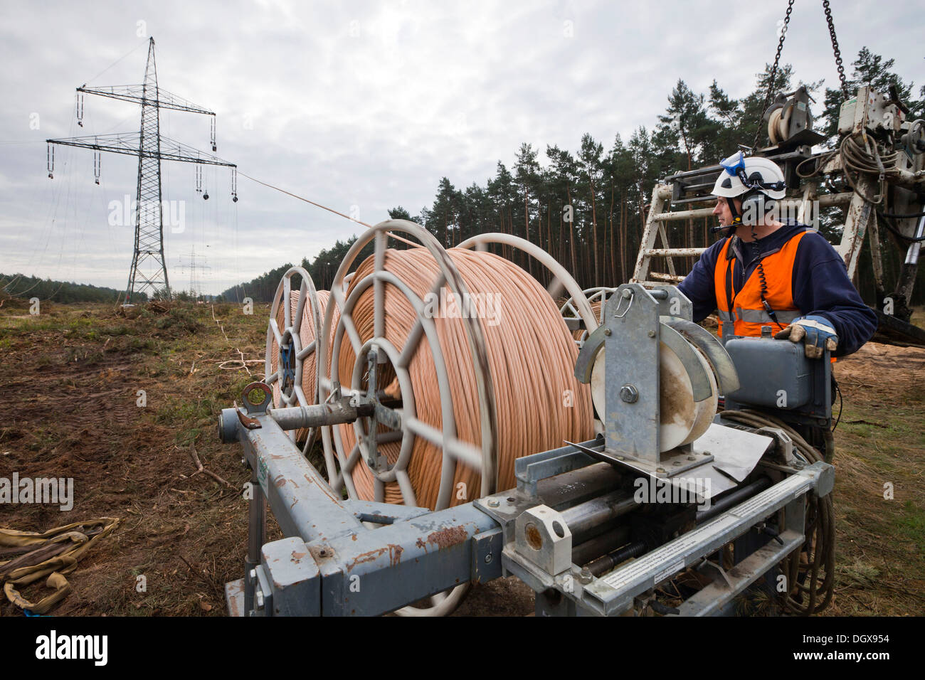 Lineman working with a wire rope hoist on a 380-kV long-distance line owned by the 50Hertz transmission system operator, track Stock Photo